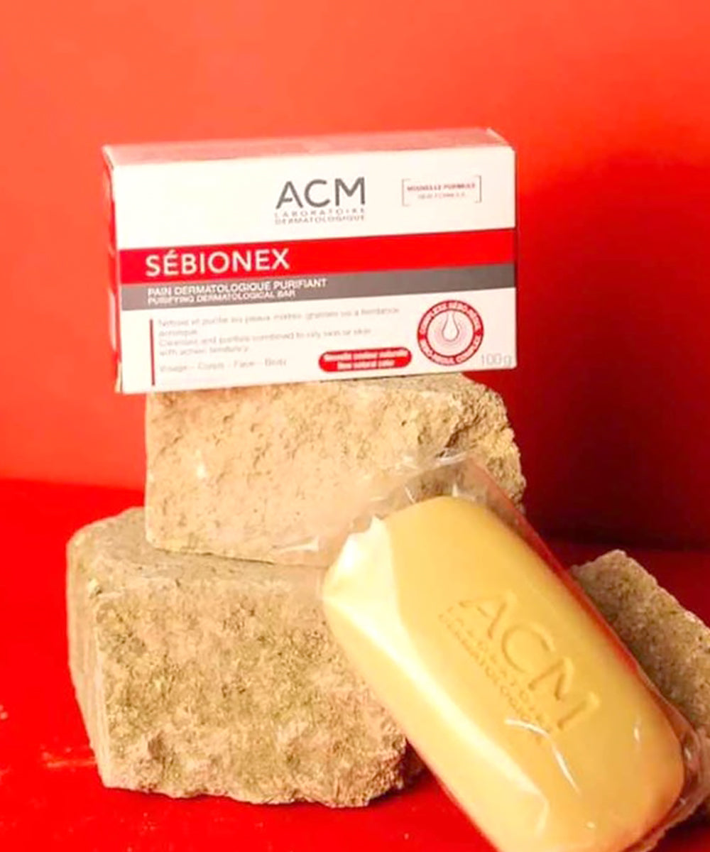Two bars of soap and a box labeled 'ACM Sébionex' on a red background