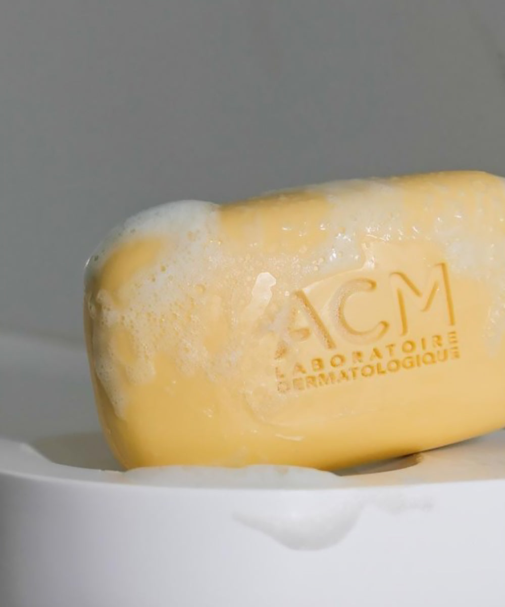 Bar of soap with 'ACM Laboratoires Dermatologiques' branding on a white surface.
