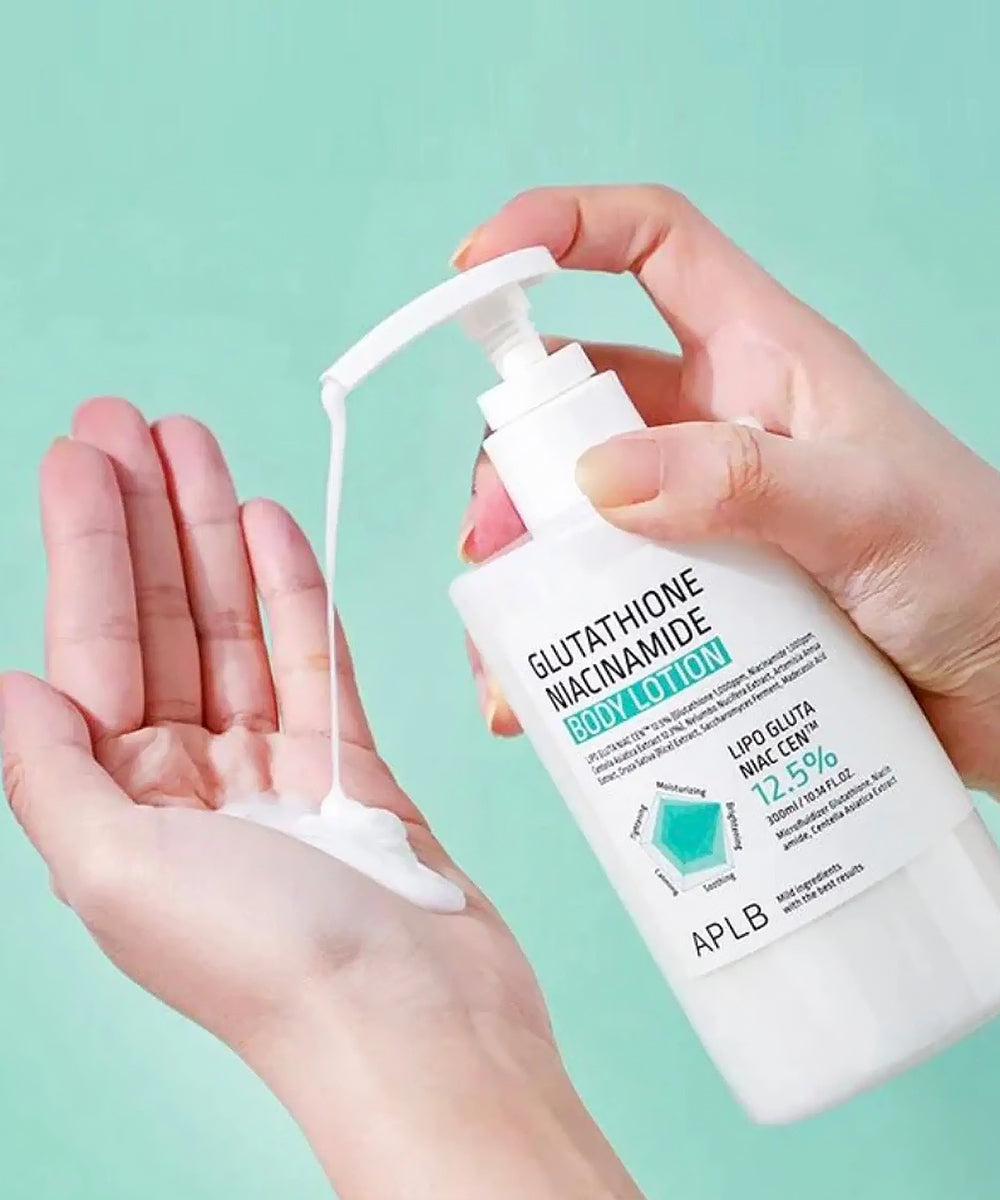Hand holding a bottle of APLB Glutathione Niacinamide body lotion with a green background