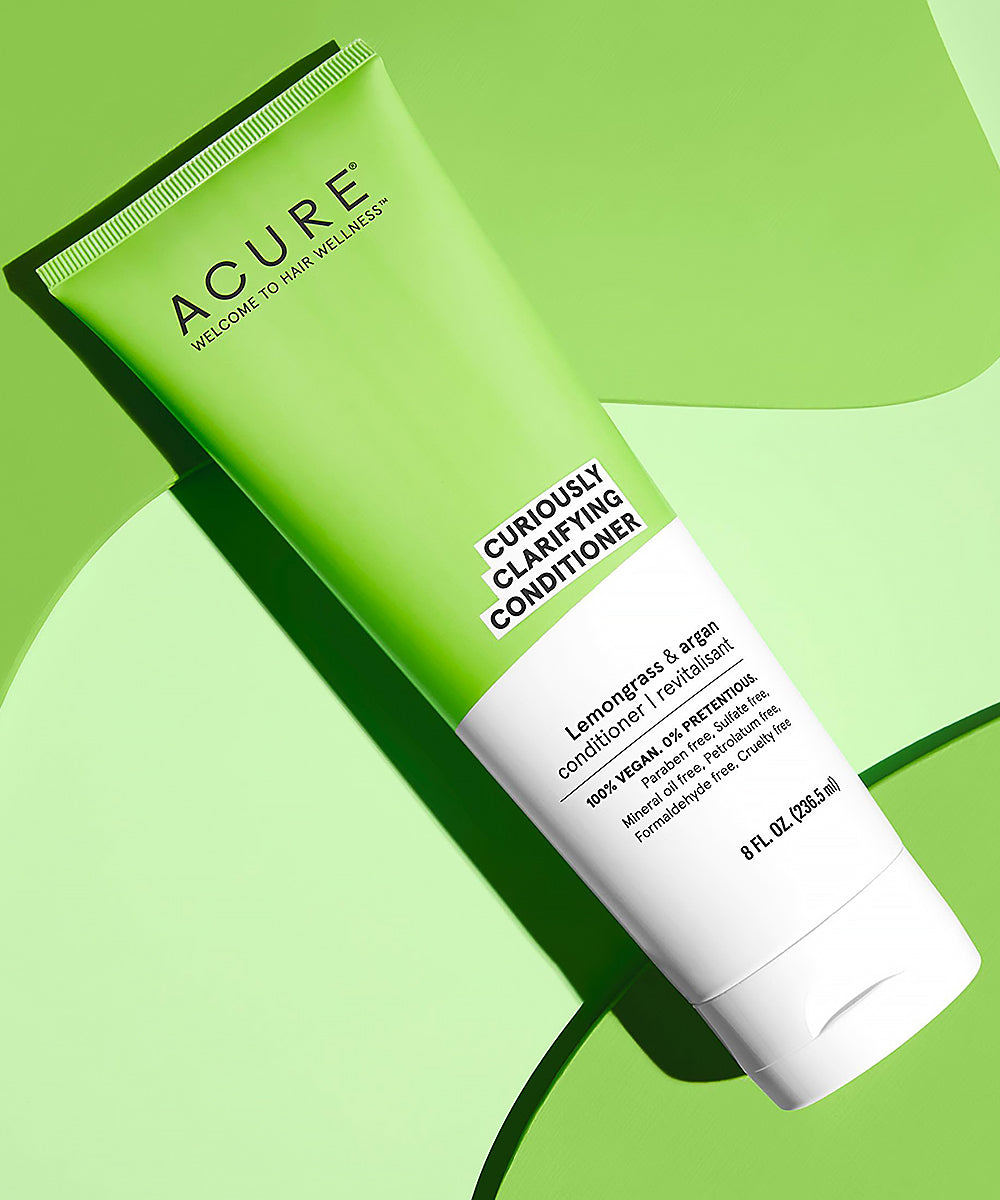 Acure Curiously Clarifying Conditioner tube on a green background