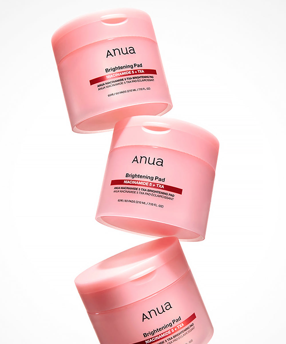 Three pink containers of Anua Brightening Pad on a white background