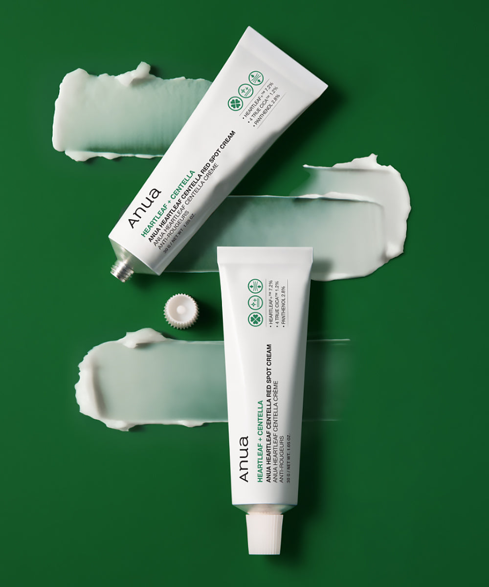 Two tubes of Anua cream on a green background with visible cream smears.