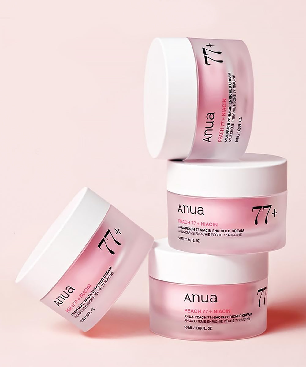 Anua skincare products with peach and niacin on a pink background