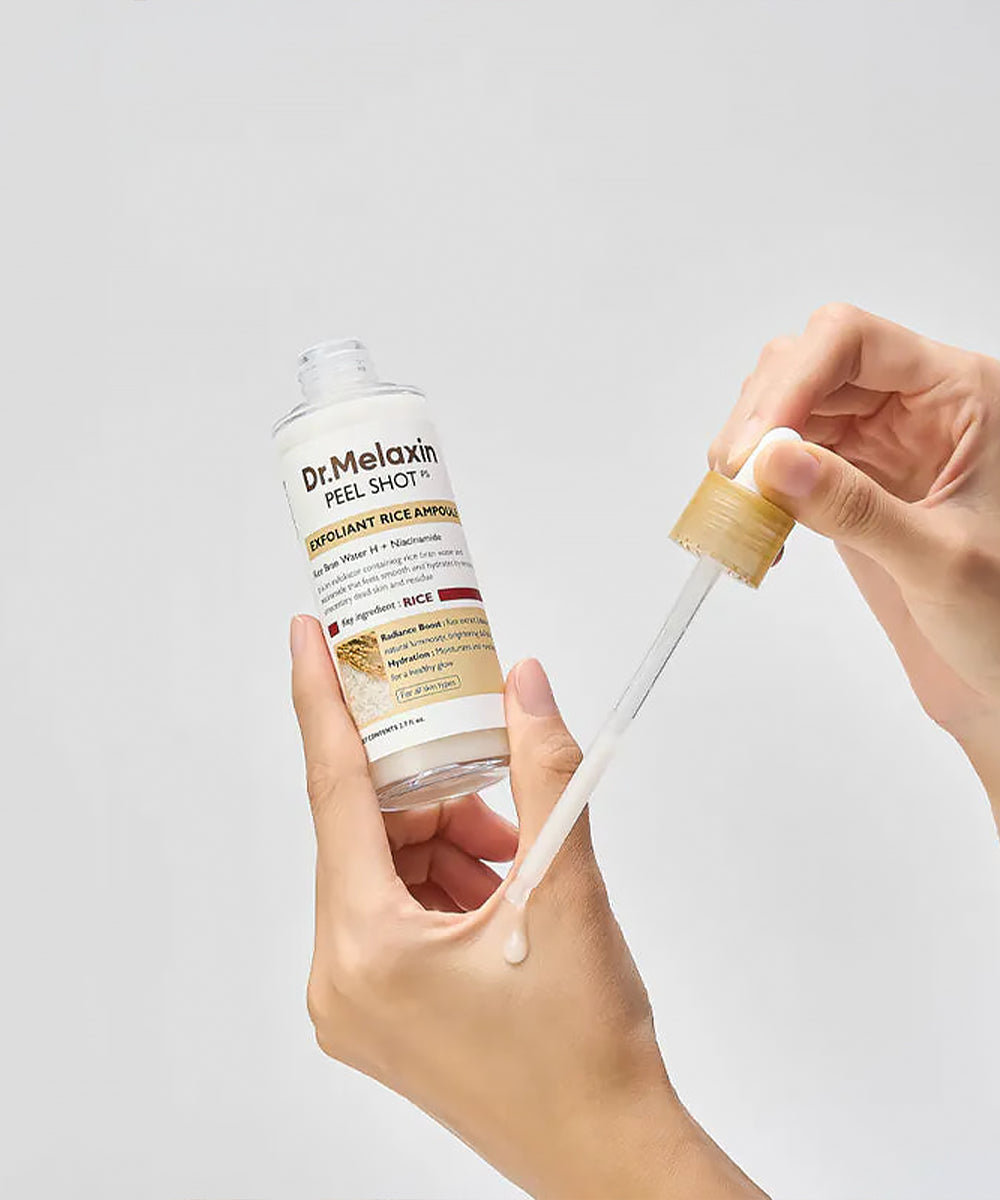 Dr. Melaxin peel shot with a dropper held by a hand against a light gray background