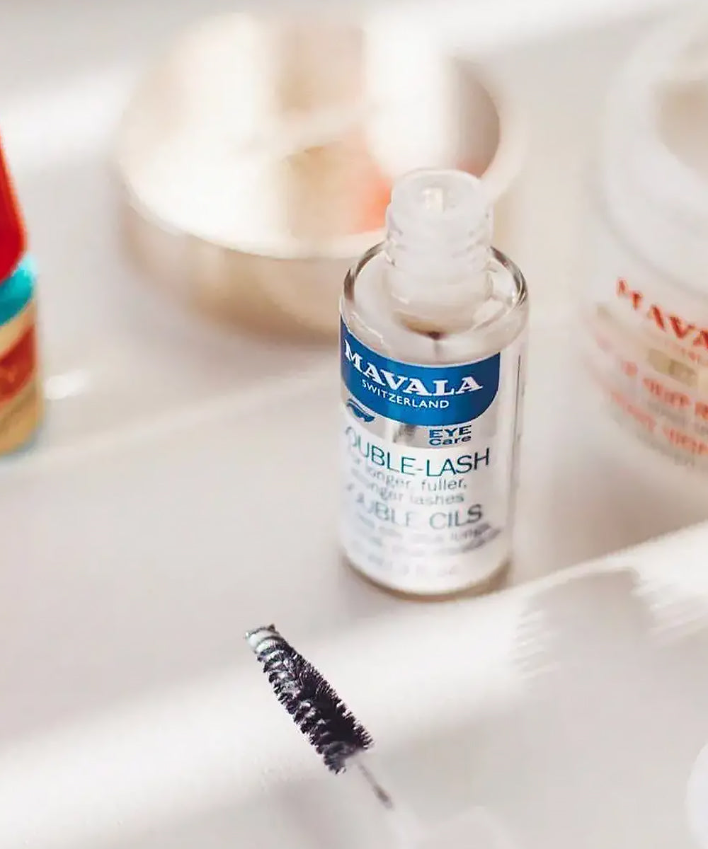 Mavala Double Lash eyelash serum bottle with brush on a white surface