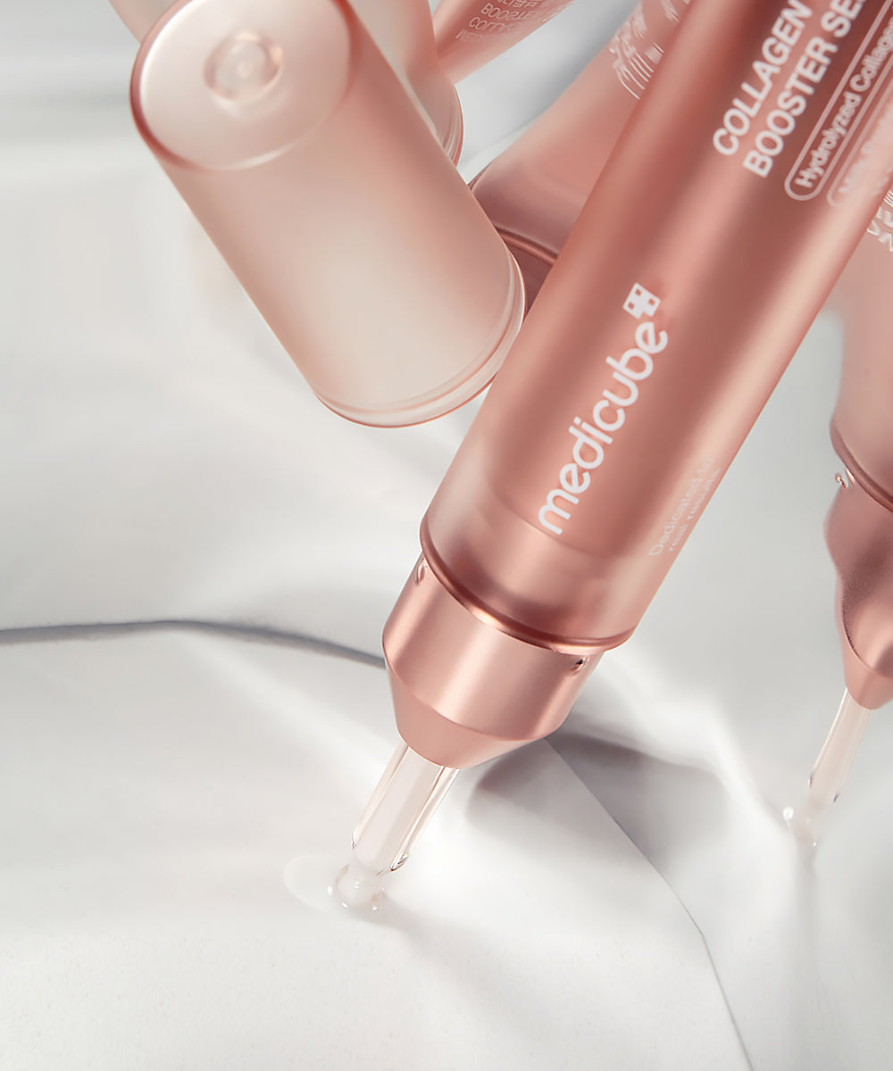 Rose gold skincare serum bottles with 'medicube' branding on a light background