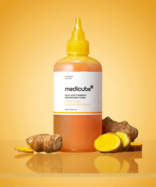 Bottle of Medicube toner with turmeric roots on a yellow background