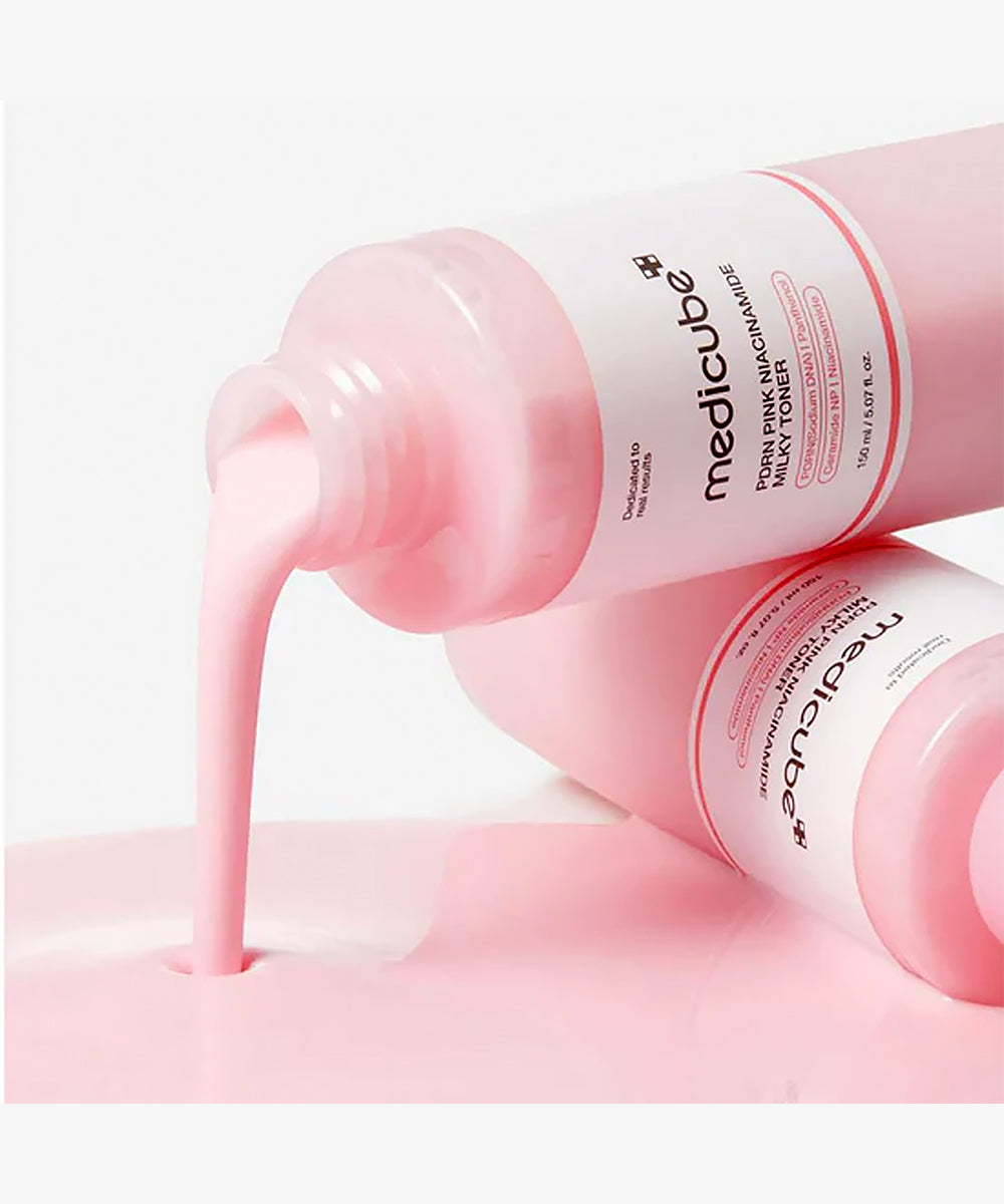 Pink bottle of Medicube toner with pink liquid being poured on a light pink background