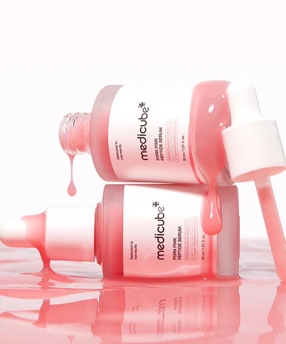 Two Medicube skincare bottles with pink liquid on a white background