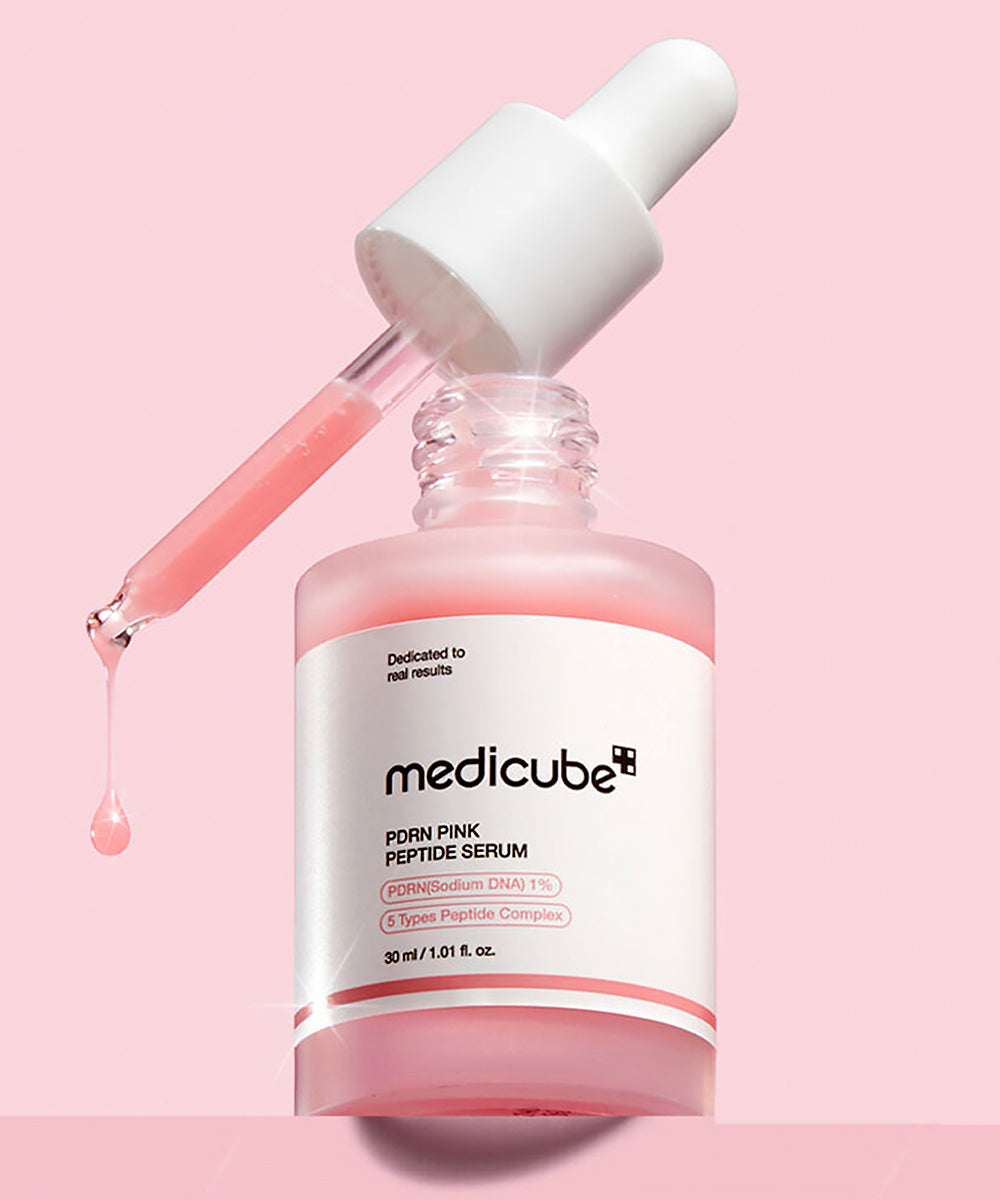 Medicube Pink Peptide Serum bottle with dropper on a pink background