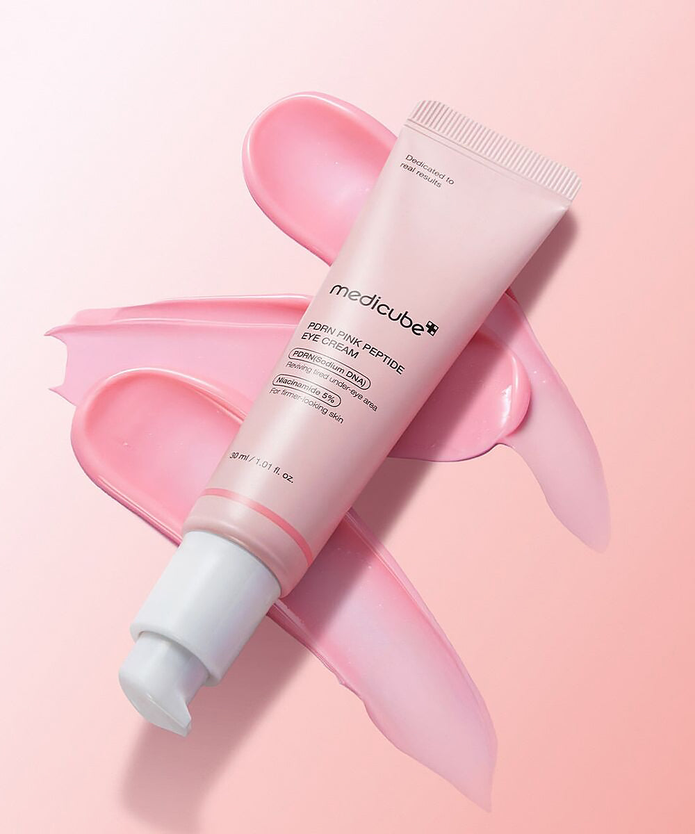 Medicube eye cream on a pink background