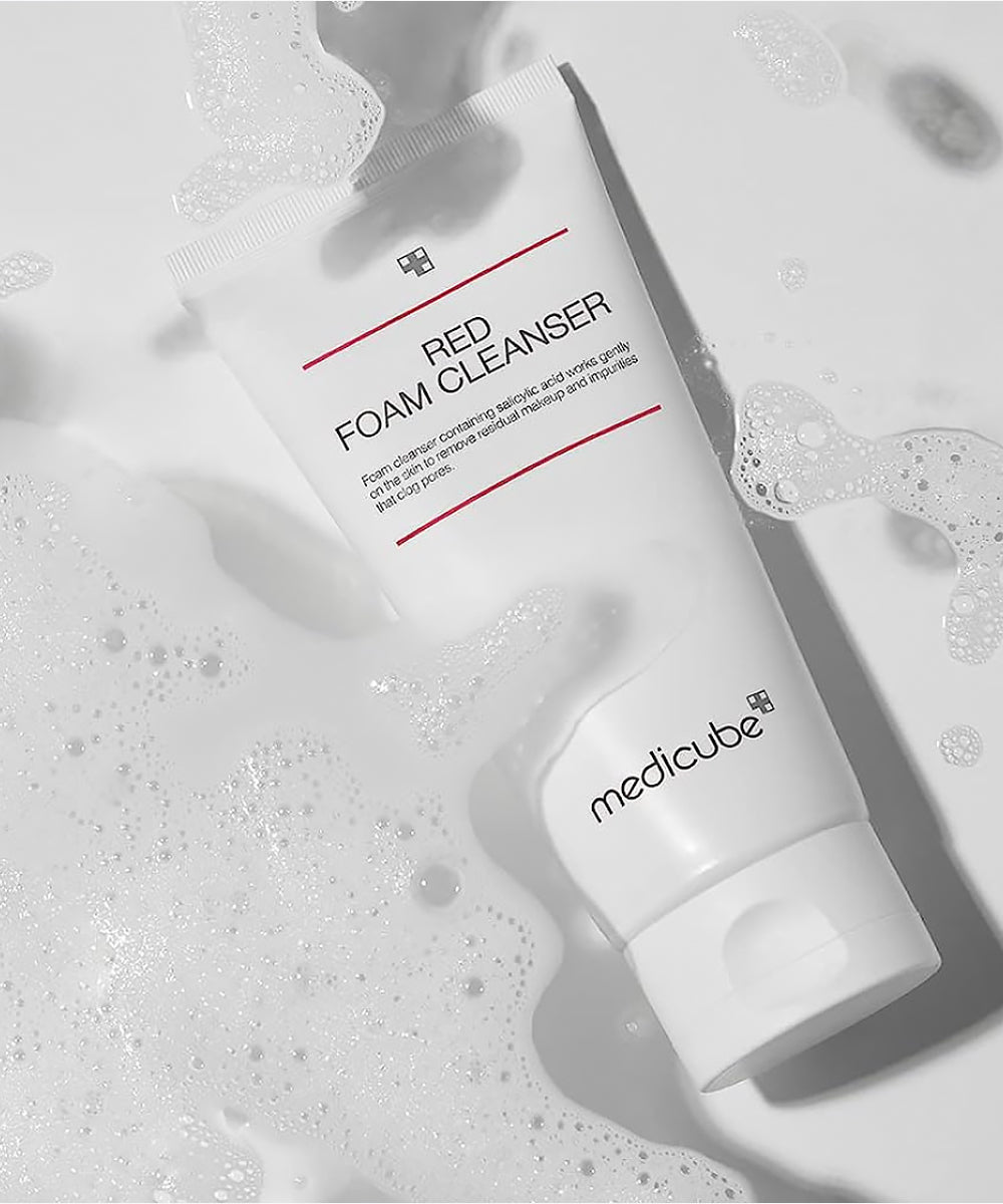 White foam cleanser tube labeled 'Red Foam Cleanser' by Medicube on a light gray background with bubbles.
