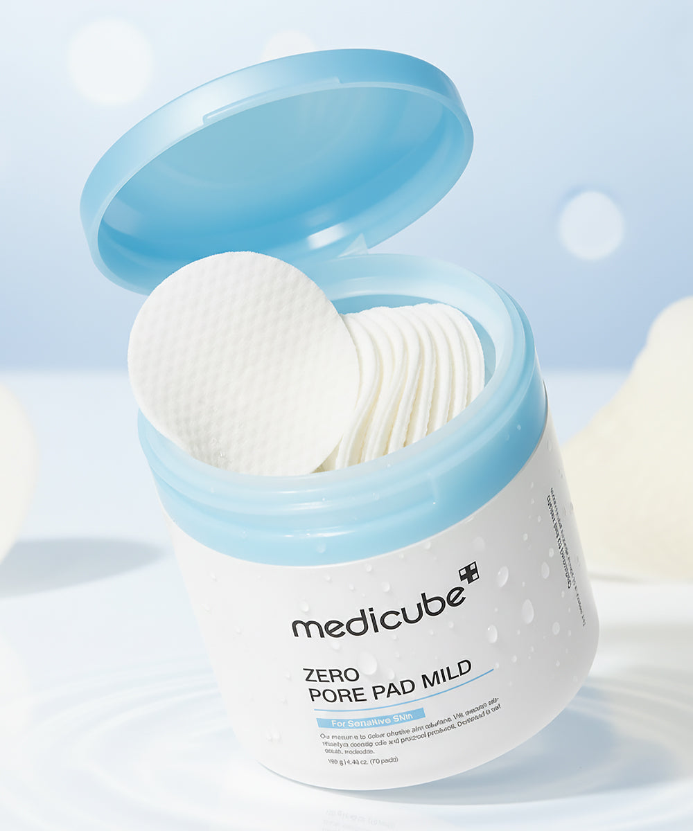 Jar of Medicube Zero Pore Pad Mild with cotton pads inside on a light blue background