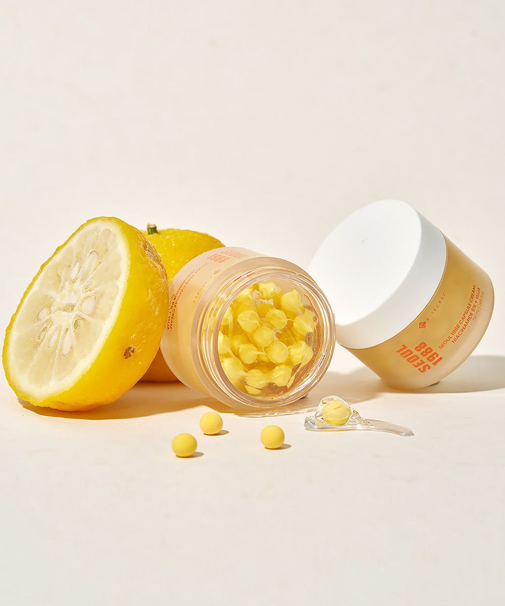 Jar of lemon-flavored gummy bears with a sliced lemon on a light background