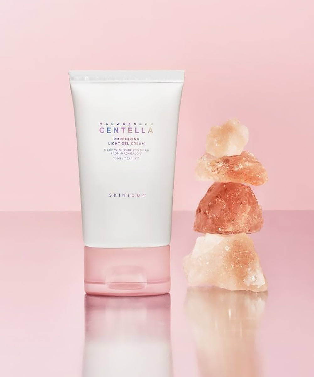 Skincare product with stacked stones on a pink background