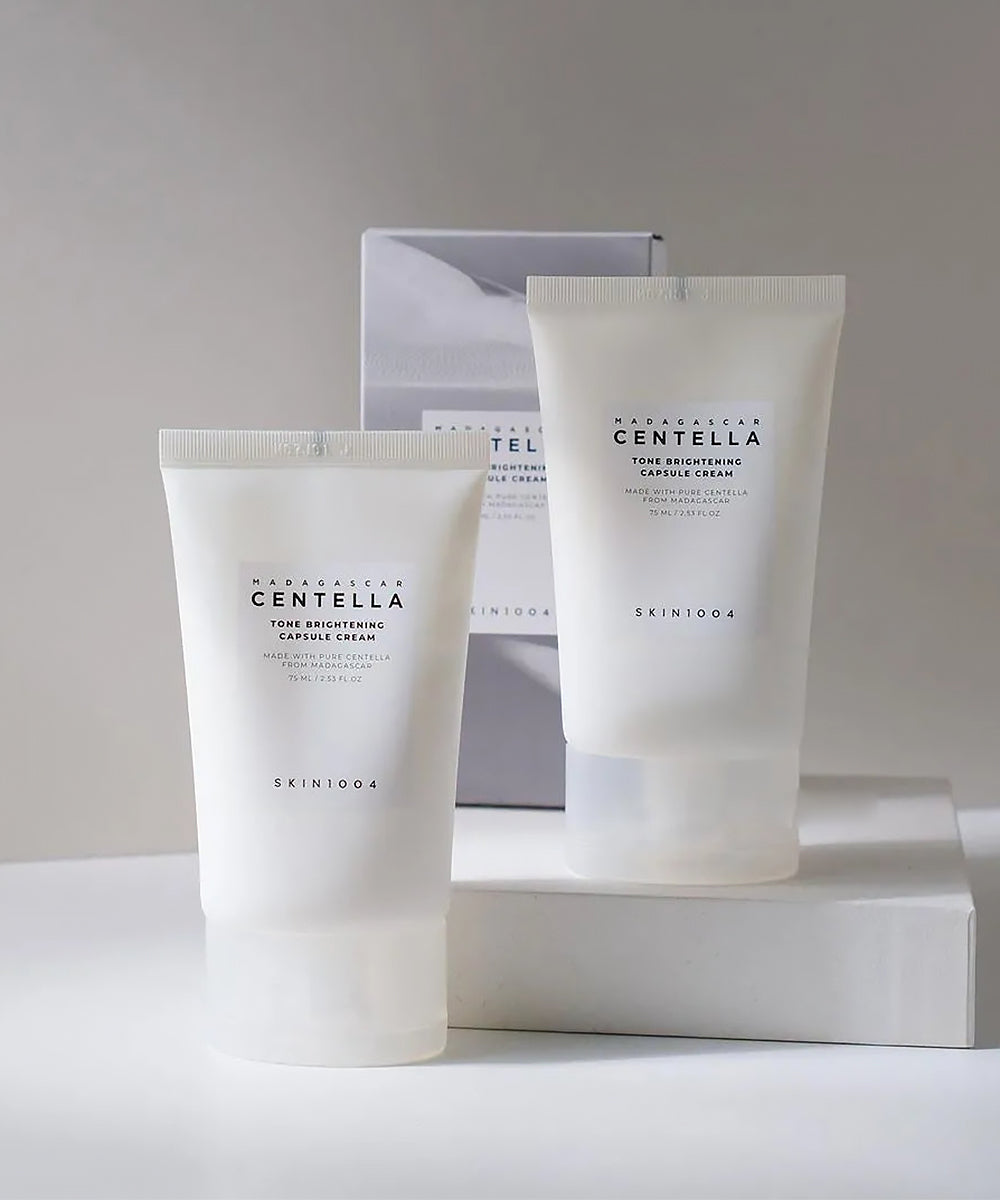 Two skincare cream tubes with 'SKIN1004' branding on a neutral background