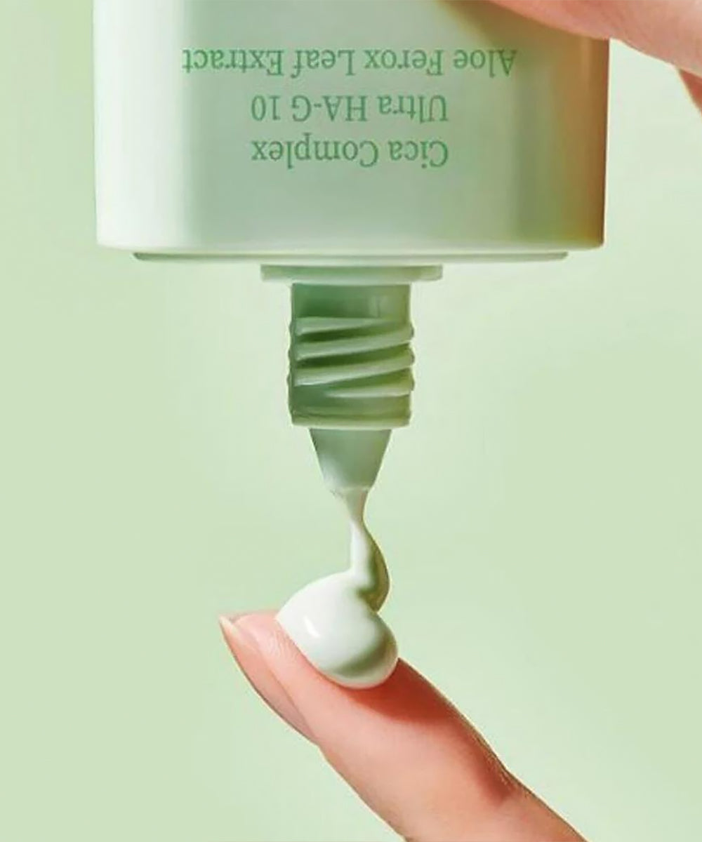 Close-up of a skincare product being applied to a finger with a green background