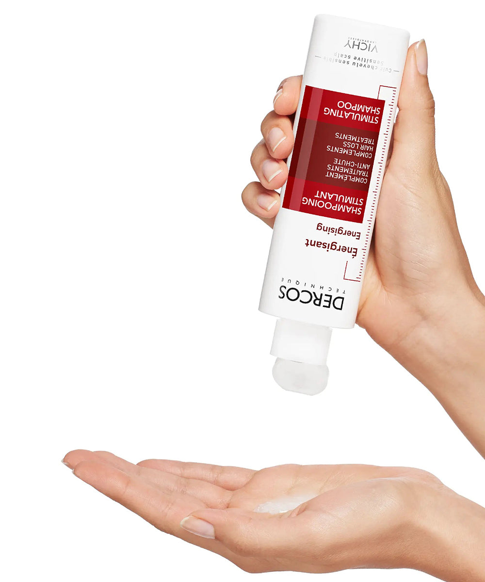 Hand holding a tube of DERDOC skincare product with visible cream on the palm against a white background