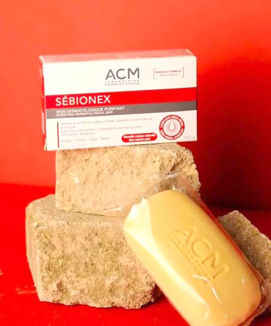 Two bars of soap and a box labeled 'ACM Sébionex' on a red background