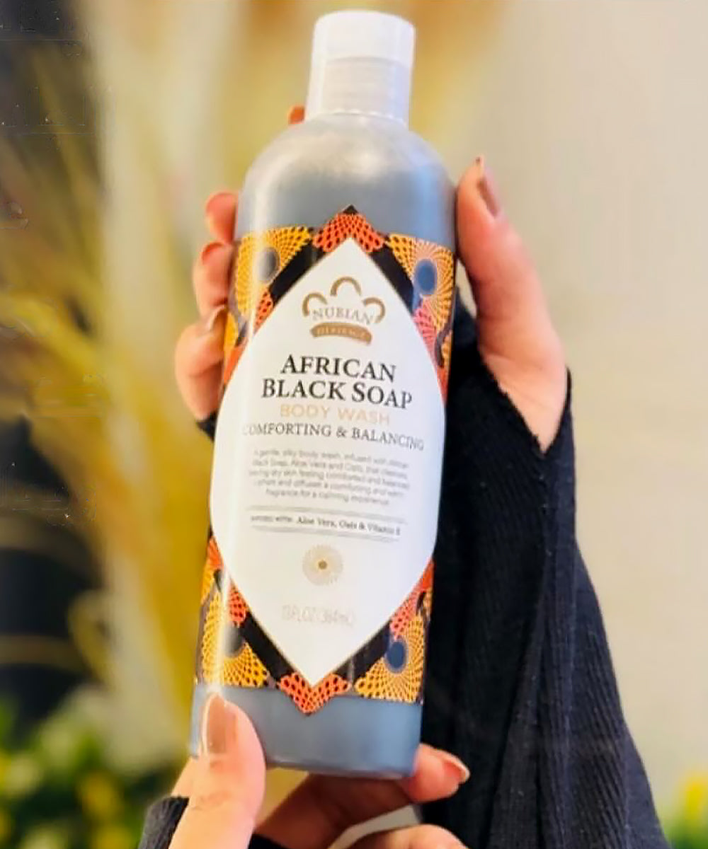Person holding a bottle of African Black Soap body wash with a blurred background