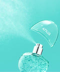 Turquoise spray bottle with a clear cap on a teal background