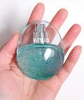 Hand holding a small blue bottle with 'Anua' branding against a white background