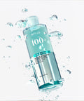 Anua 100+ toner bottle with water droplets on a white background