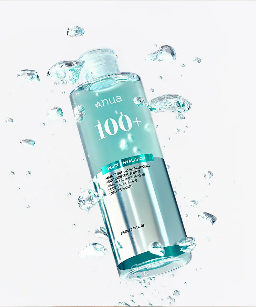 Anua 100+ toner bottle with water droplets on a white background