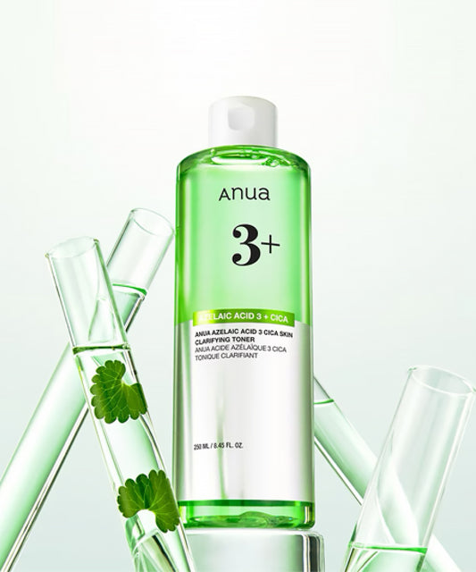 A creative product shot of the Anua toner bottle surrounded by glass laboratory test tubes containing green Centella Asiatica (Cica) leaves, emphasizing its scientific formulation