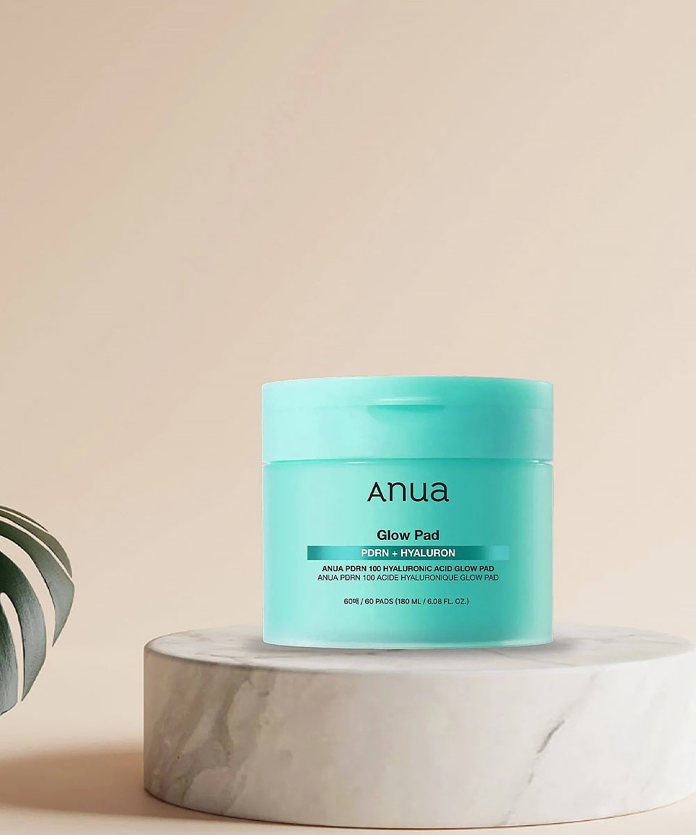 Blue jar of Anua Glow Pad on a beige background