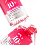 Anua Niacinamide 10+ TXA4 serum bottle with pink liquid being poured out on a white background