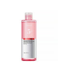 Skincare bottle with pink liquid and white label on a white background