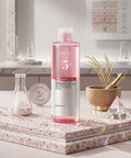 Pink skincare bottle with white label on a marble surface