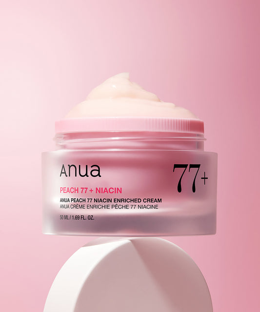 Anua Peach 77 + Niacin enriched cream jar on a pink background