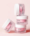 Anua skincare products with peach and niacin on a pink background