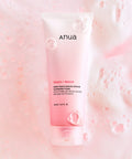 Anua Peach + Niacin cleansing foam packaging on a pink background with bubbles