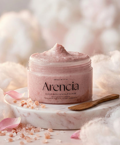 Jar of Arencia cloud body and scalp scrub on a soft, blurred background with pink petals and a wooden spoon.