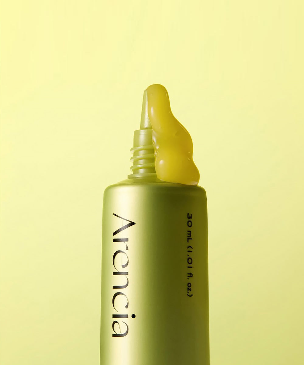 Skincare serum bottle with yellow dropper on a light yellow background