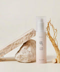 Skincare bottle with natural elements on a light background