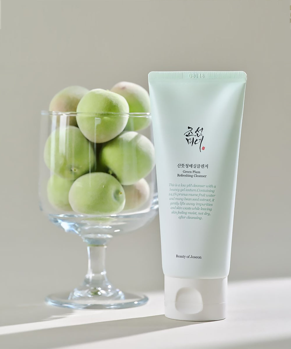 Tube of cleanser with green fruits in a glass on a neutral background