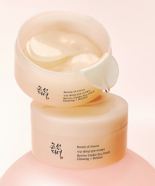 Tilted and stacked product display of two Beauty of Joseon Revive Under Eye Patch jars, with the top jar open to reveal the gel patches and applicator spatula inside.