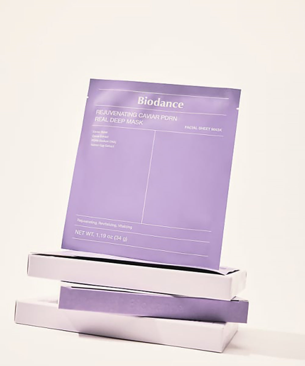 A single purple mask sachet propped up on a stack of two white Biodance boxes.