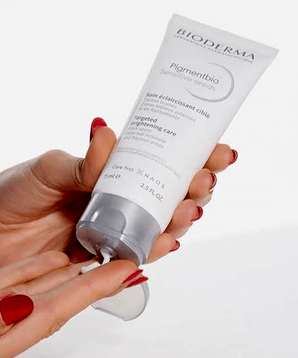 Hand holding a Bioderma skincare product on a white background
