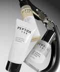 CosRX Peptide 132 hair care products with a hair straightener on a gray background
