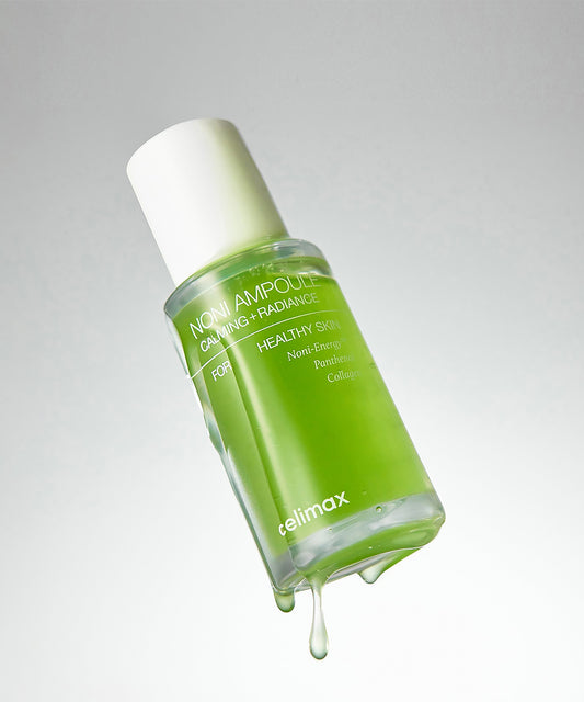 Green skincare bottle with white cap on a gray background