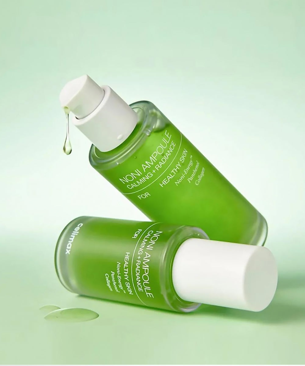 Two green skincare bottles with white caps on a light green background
