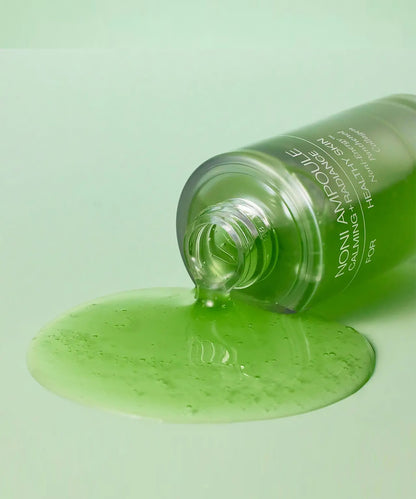 Green skincare product with a dropper on a light green background
