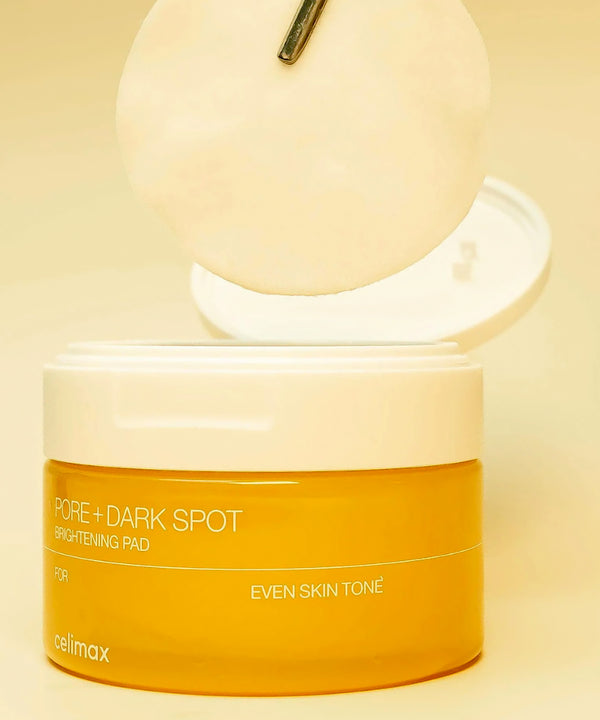 Pore + Dark Spot Brightening Pad container with a yellow label on a beige background