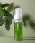 Green bottle with pump dispenser on a light green background