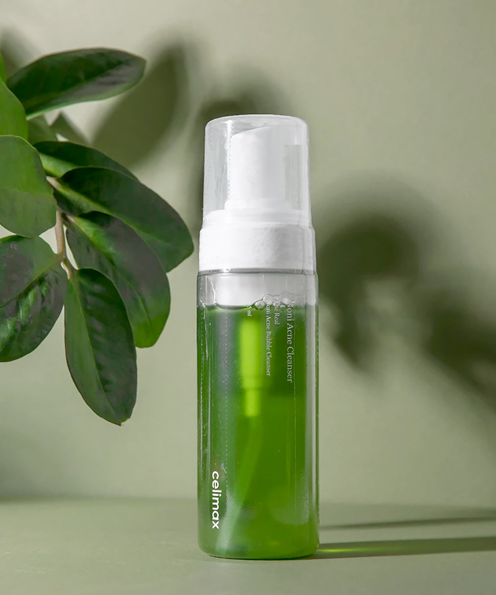 Green bottle with pump dispenser on a light green background